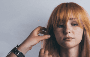 Frisör klipper rödhårig tjejs hår